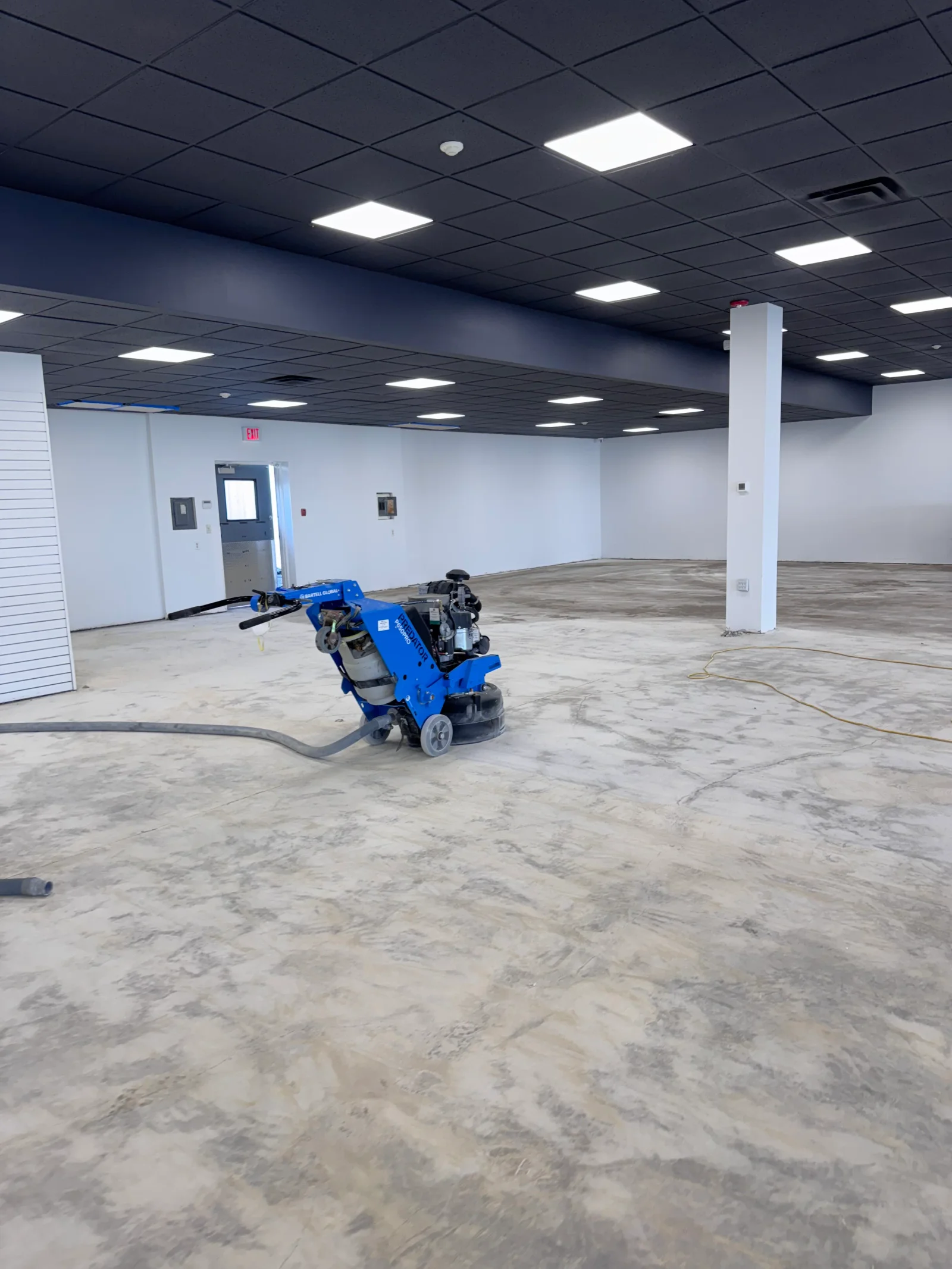 Concrete floor grinding equipment preparing large commercial concrete surface for coating