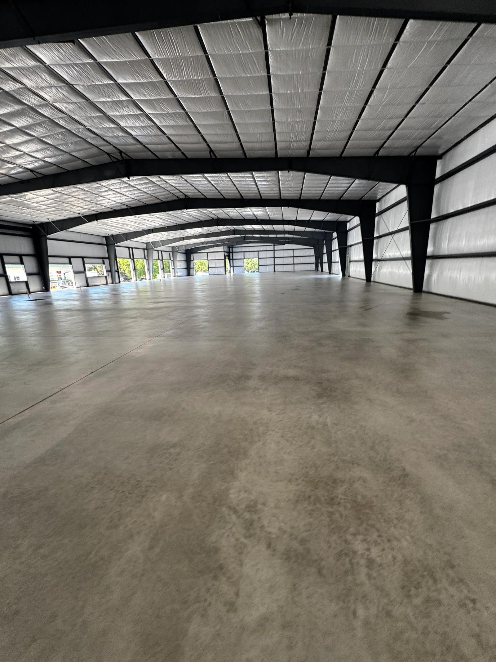 Polished concrete floor in industrial warehouse with steel frame and translucent roof panels