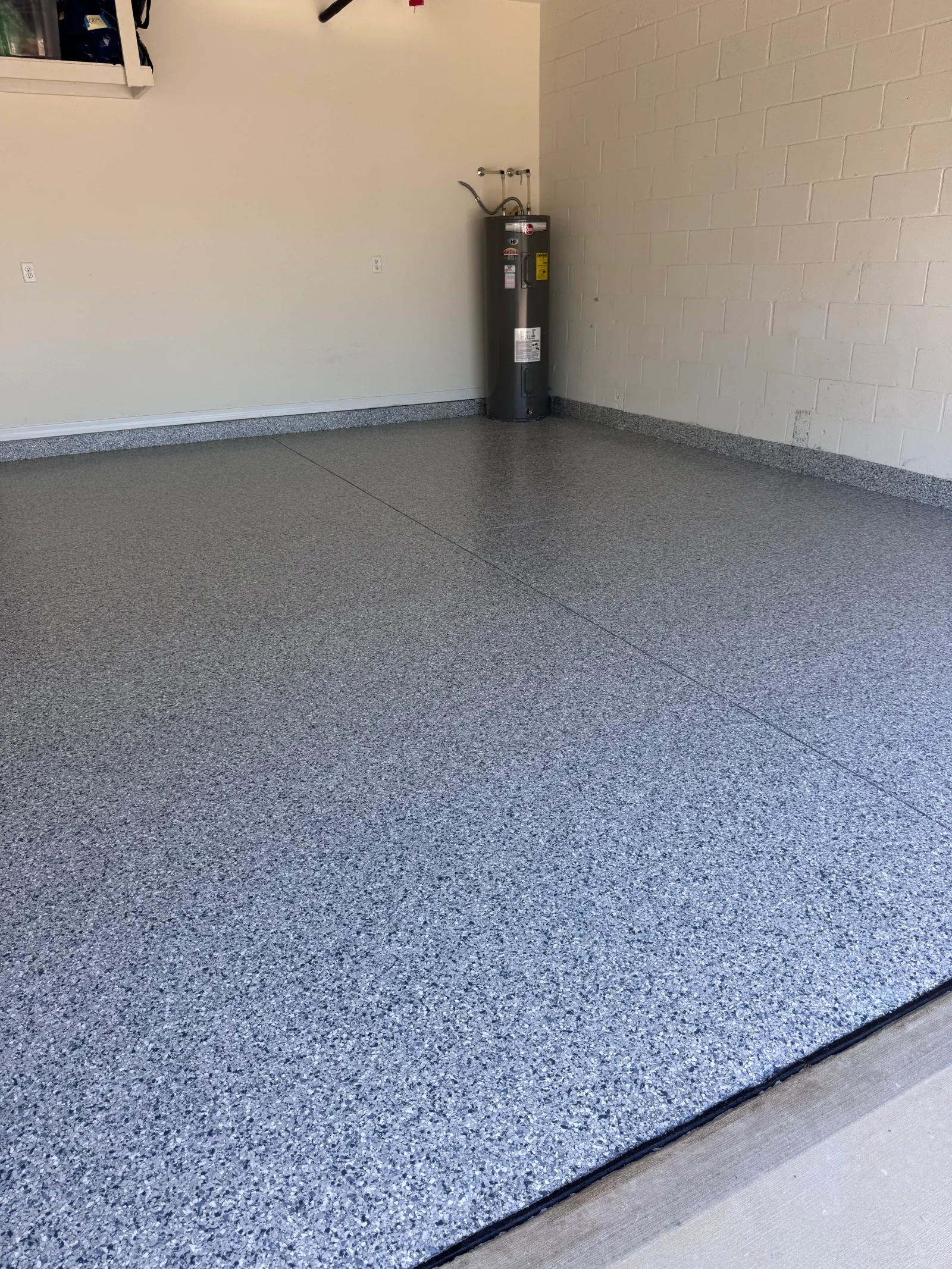Gray speckled epoxy-coated garage floor with clean seams and finished edges